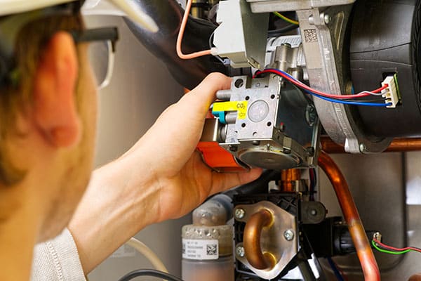 Technician repairing a furnace control board